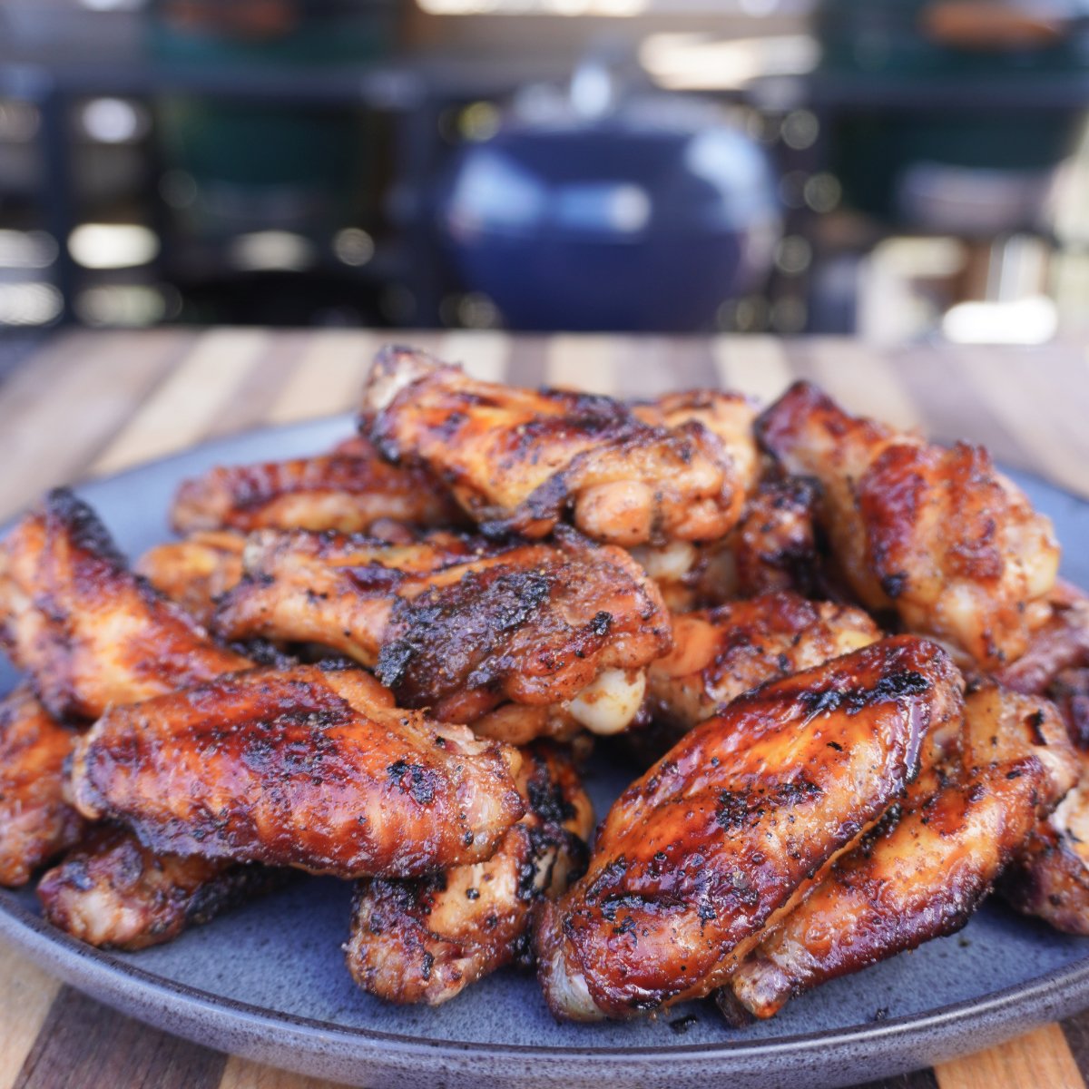 a pile of grilled maple bourbon wings  on a plate.